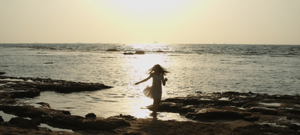 ילדה רוקדת על חוף הים